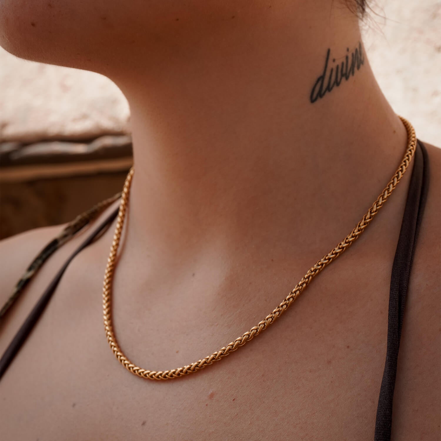 female wearing 3mm gold wheat chain on neck