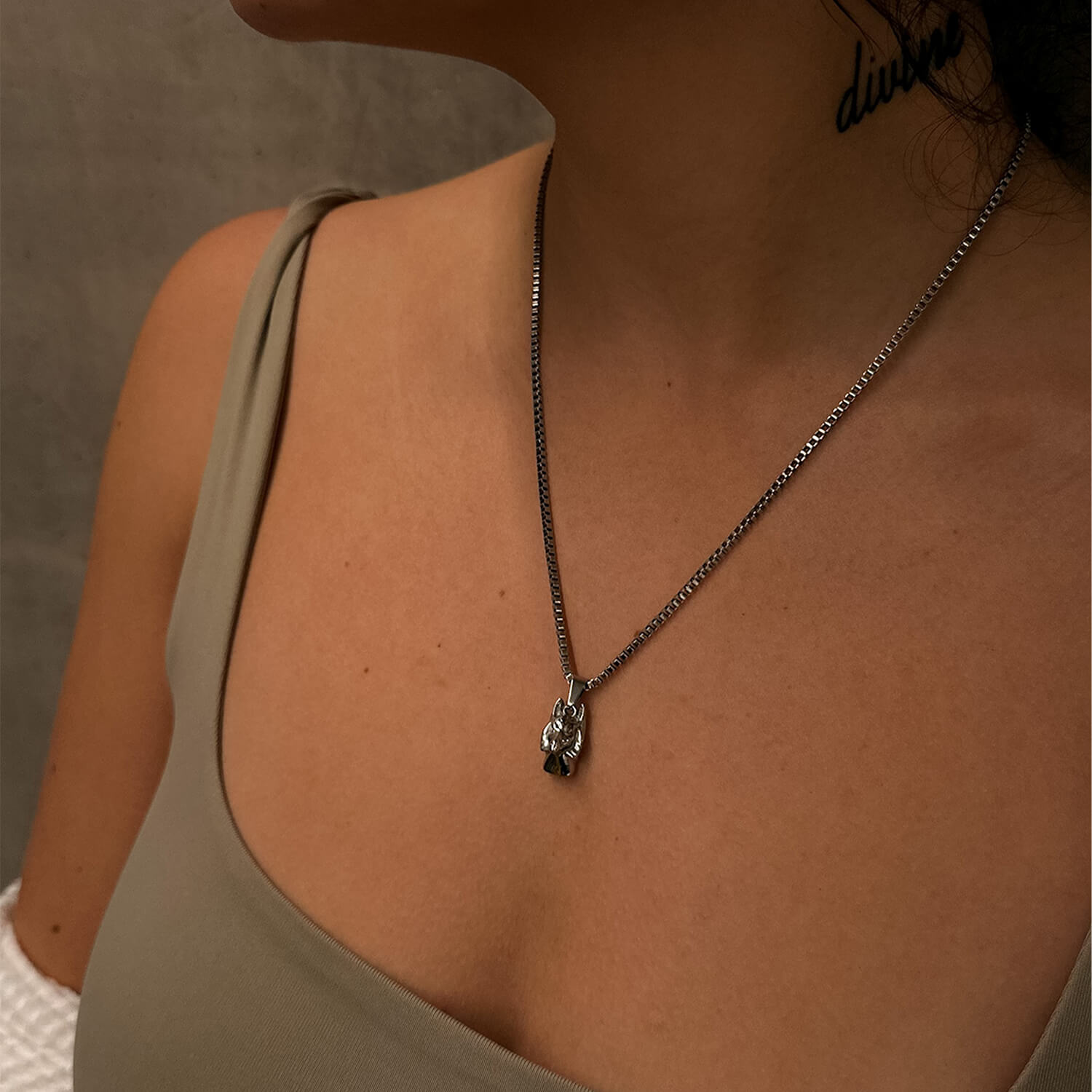 female wearing silver anubis pendant on neck