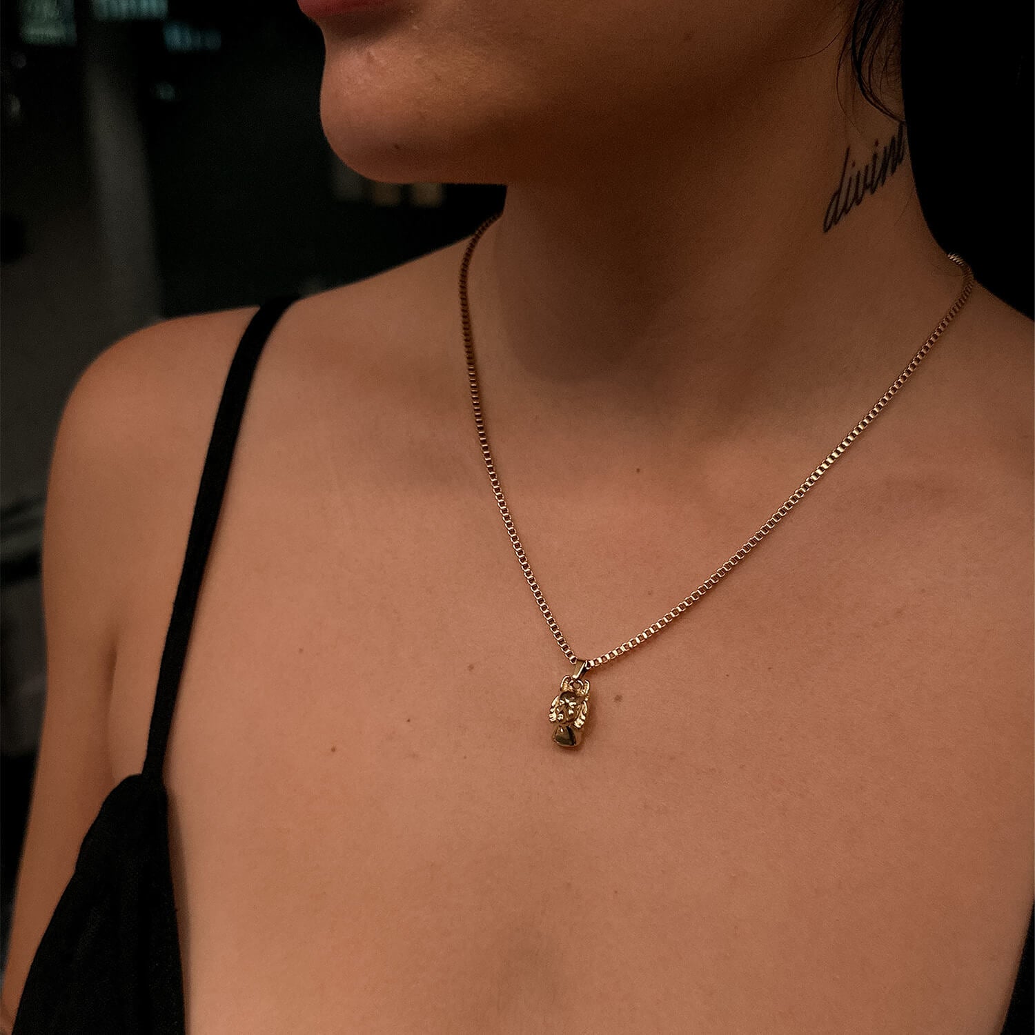female wearing gold anubis pendant on neck