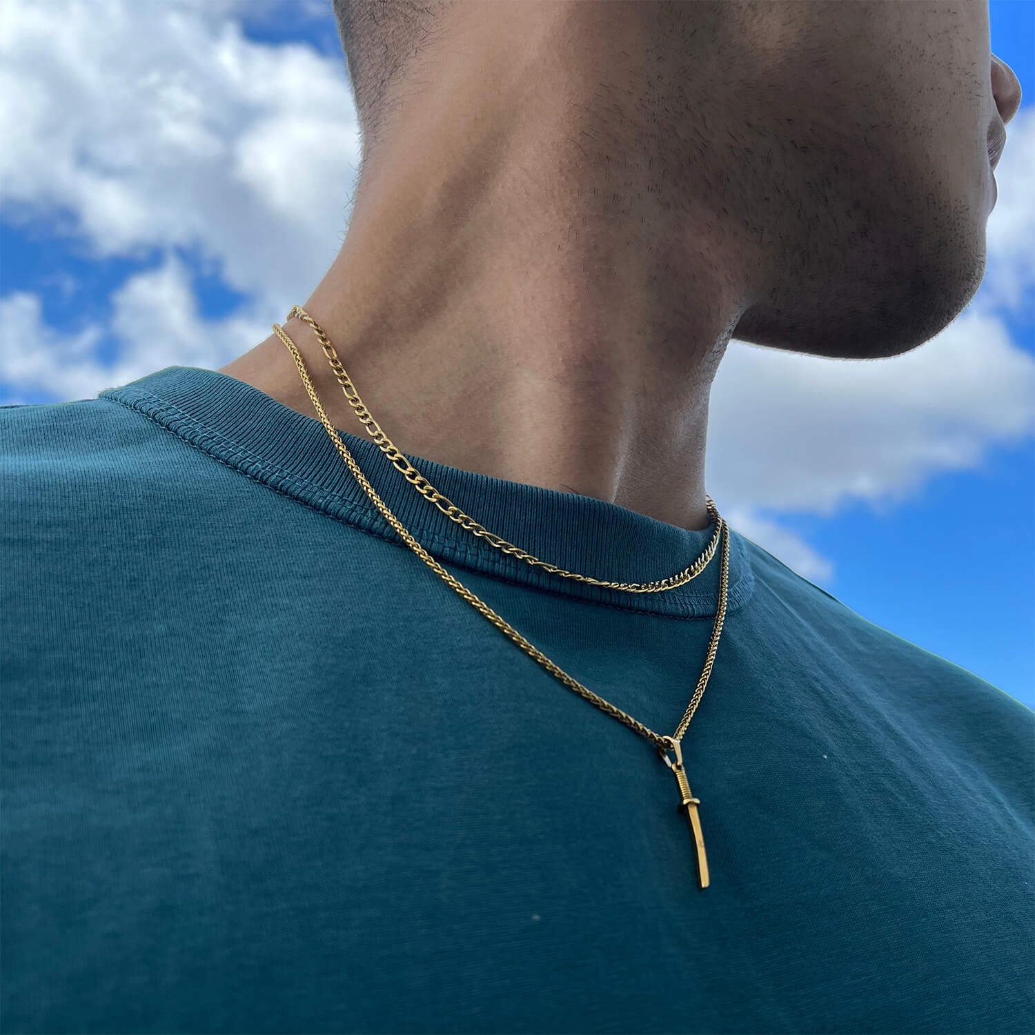 male wearing gold katana pendant on neck